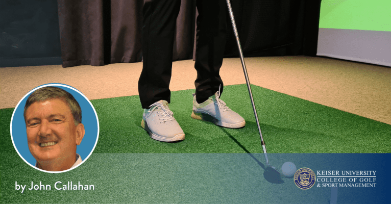 Golfer using a video analysis hitting bay to improve their swing. 