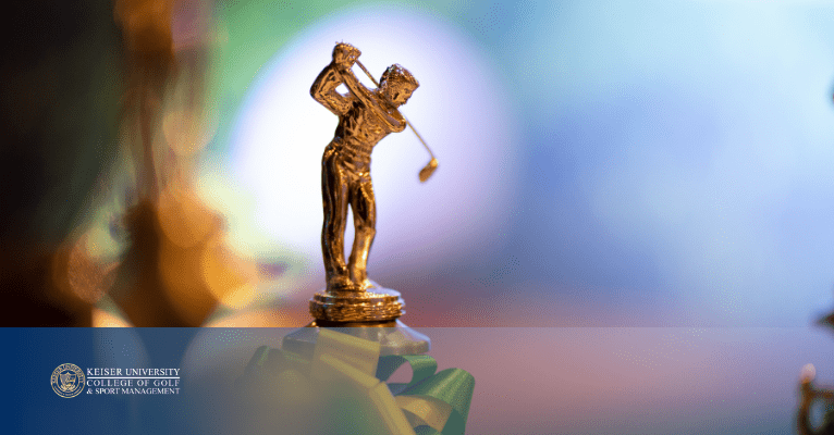 Gold golf trophy with ribbon and blurred background, symbolizing golf achievement.