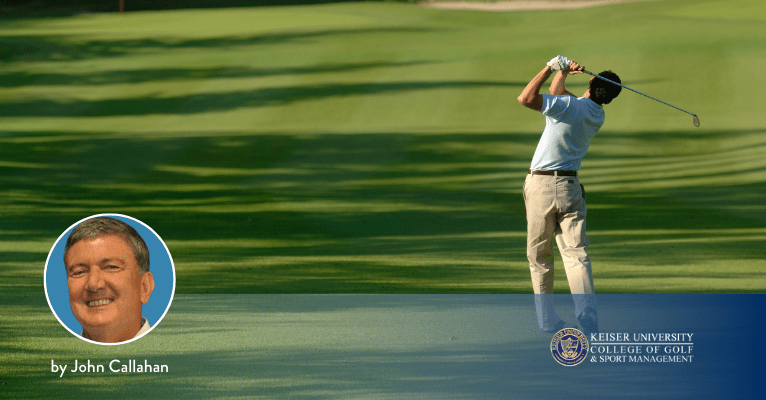 Golfer completing a balanced follow-through after striking an iron shot on the fairway.